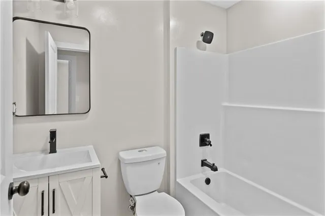 a bathroom with a toilet a sink a mirror and bathtub