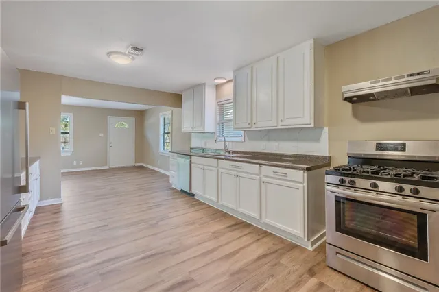 a kitchen with stainless steel appliances granite countertop a stove and a sink