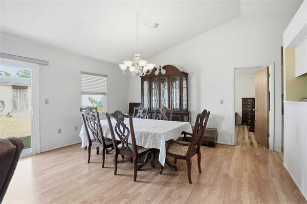 a view of a dining room with furniture a chandelier and wooden floor