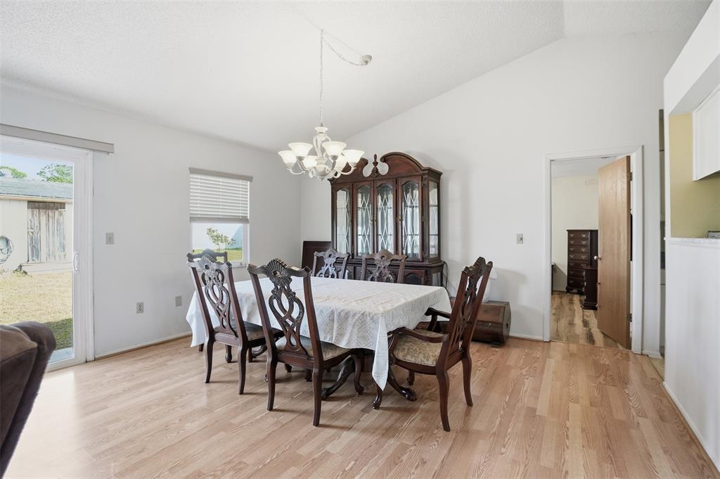 3280 Ambassador Avenue Spring Hill, FL 34609 - Photo 12 of 36 a view of a dining room with furniture and wooden floor