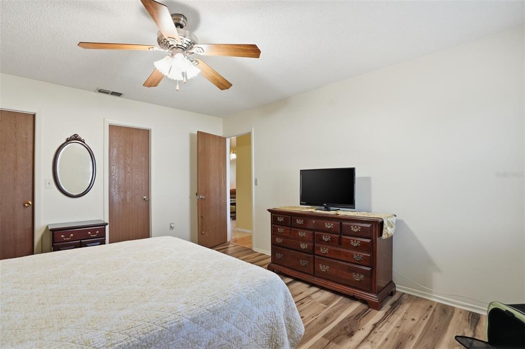 3280 Ambassador Avenue Spring Hill, FL 34609 - Photo 17 of 36 a bedroom with a bed and a flat tv screen on dresser