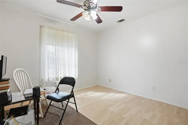 a view of a workspace with wooden floor and a ceiling fan