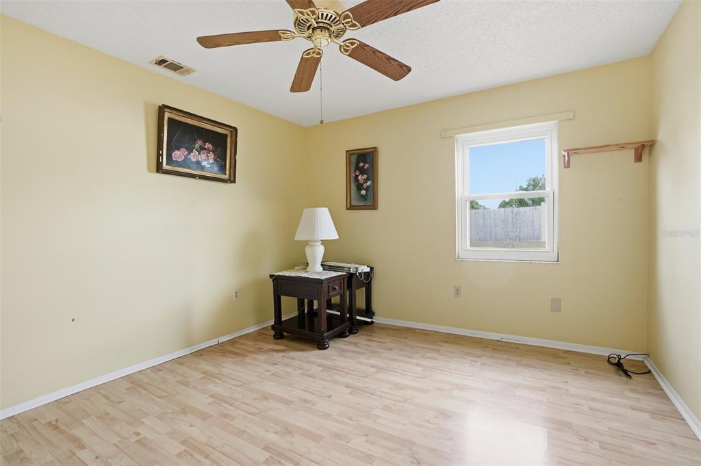 3280 Ambassador Avenue Spring Hill, FL 34609 - Photo 19 of 36 a view of a workspace with wooden floor and a ceiling fan