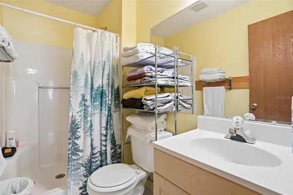 a bathroom with a sink toilet vanity and shower