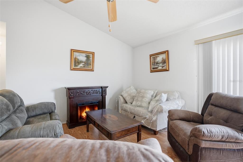 3280 Ambassador Avenue Spring Hill, FL 34609 - Photo 4 of 36 a living room with furniture and a fireplace