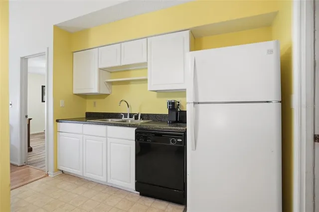 a kitchen with stainless steel appliances granite countertop a refrigerator a stove a sink dishwasher with a dining table and chairs