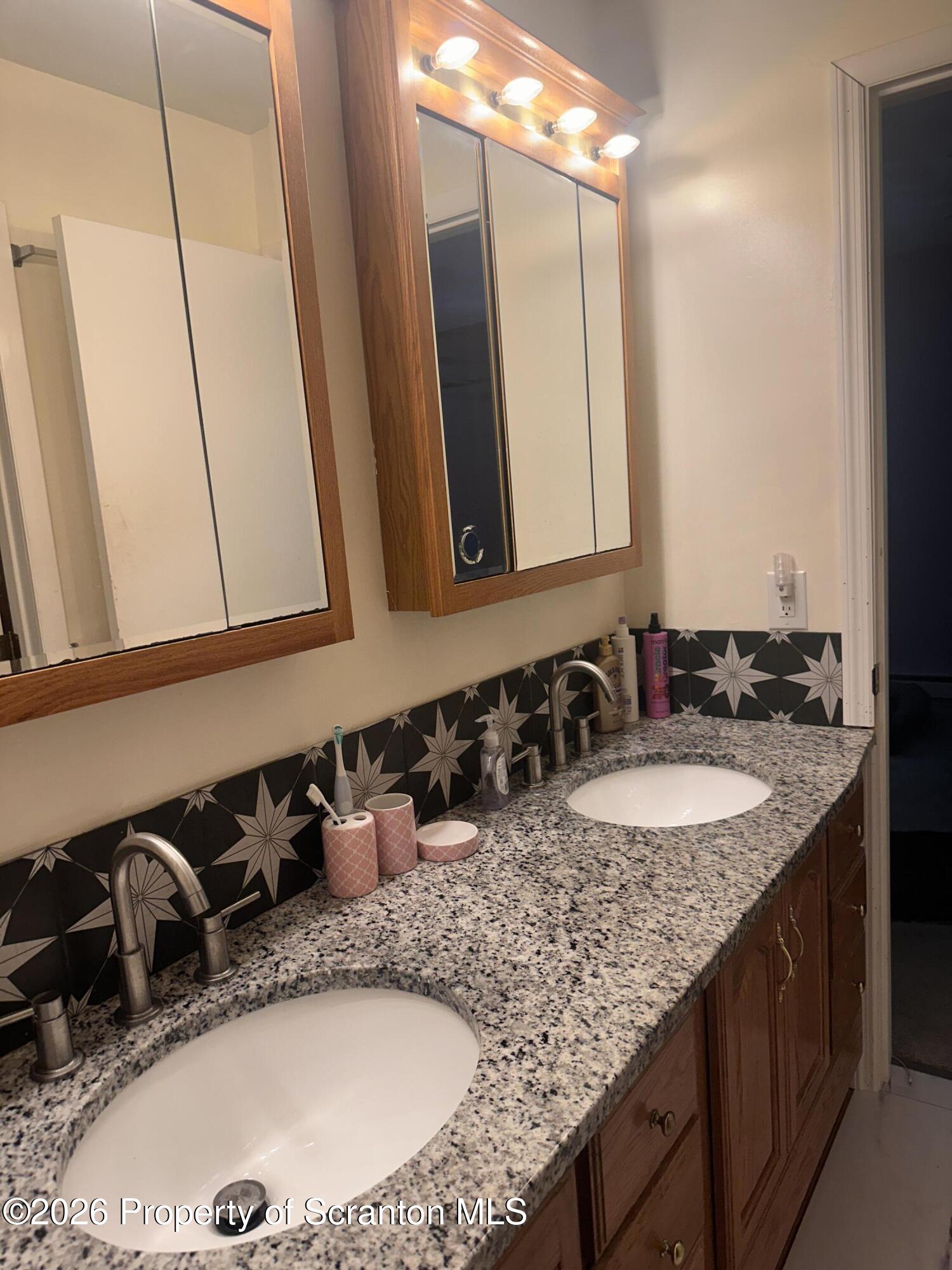 107 Keystone Hls Road, Unit 405 Factoryville, PA 18419 - Photo 27 of 27 a bathroom with a granite countertop sink and a mirror
