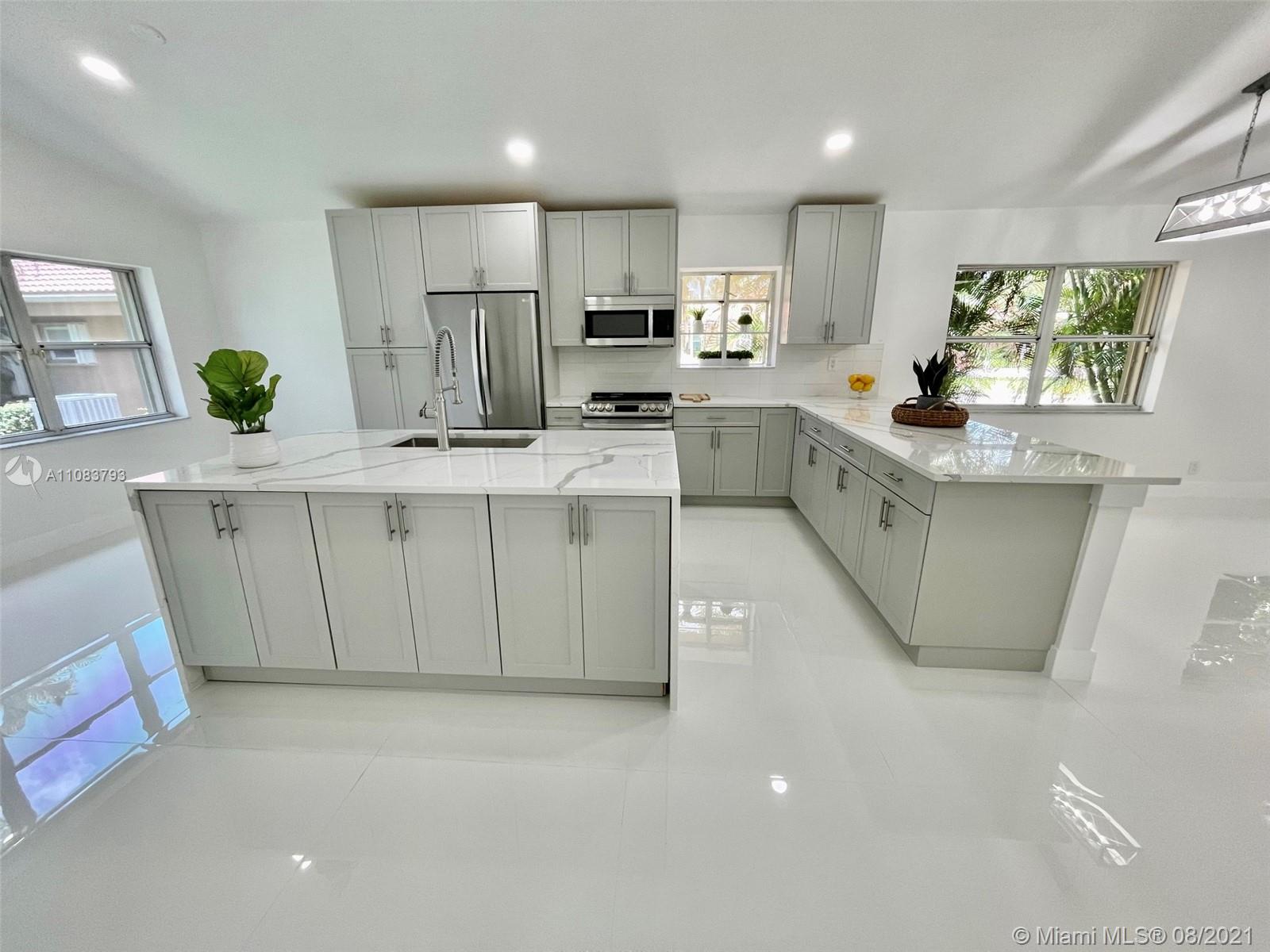 11069 Rios Road, Unit 11069 Boca Raton, FL 33498 - Photo 4 of 14 a kitchen with stainless steel appliances a sink a stove a refrigerator cabinets and a window
