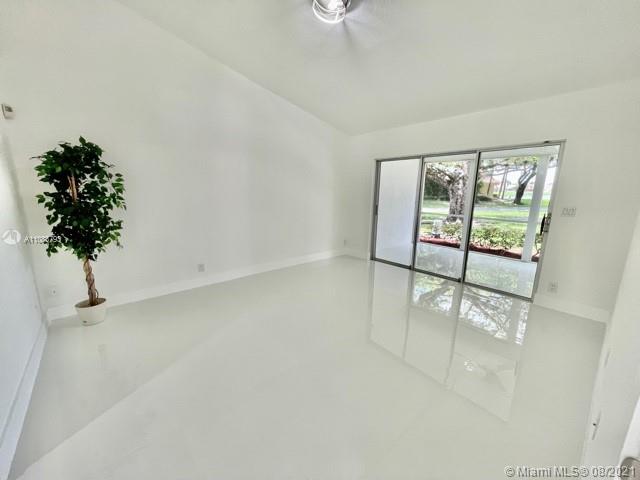 11069 Rios Road, Unit 11069 Boca Raton, FL 33498 - Photo 9 of 14 an empty room with windows and flower pot