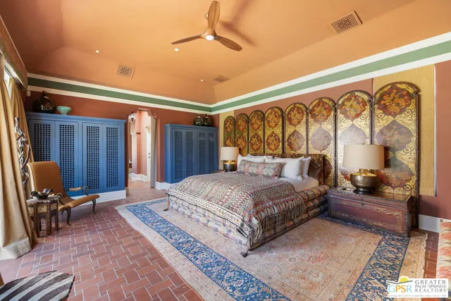 a bedroom with a large bed and a chandelier