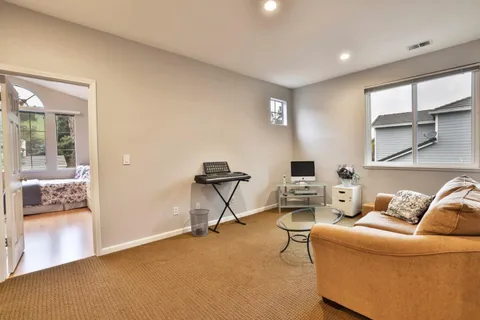 a living room with furniture a flat screen tv and a window