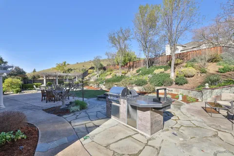 a patio with table and chairs and potted plants