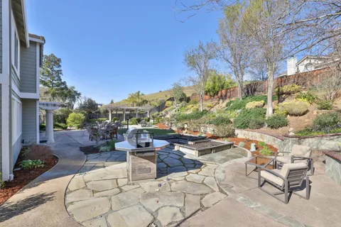 a view of a patio with couches and table and chairs with wooden fence