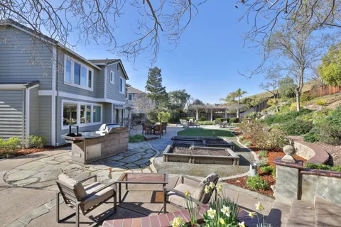 a view of a patio with table and chairs and potted plants