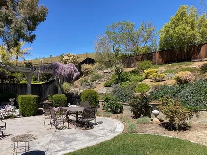 a view of a backyard with sitting area and garden