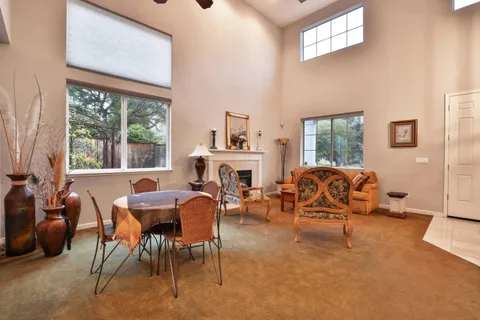 a living room with furniture a fireplace and large windows