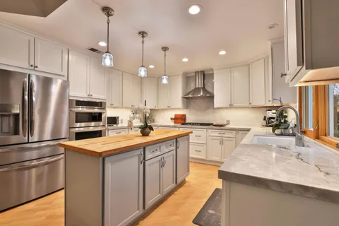 a kitchen with a sink a stove a refrigerator and a center island