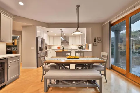 a view of a dining room and livingroom with furniture wooden floor a chandelier