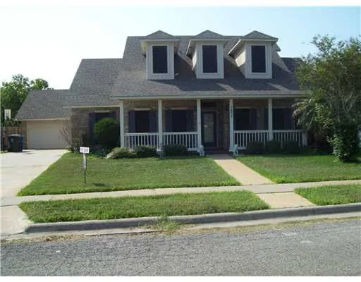a view of a brick house with a yard in front of a house
