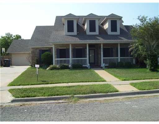 a view of a brick house with a yard in front of a house