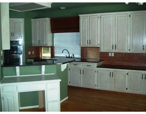 a kitchen with cabinets a sink and a microwave