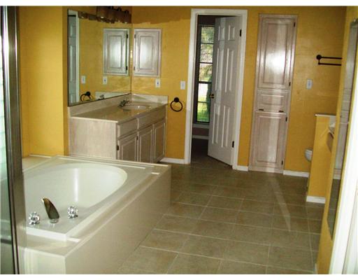 7677 Dallas Street Corpus Christi, TX 78413 - Photo 8 of 9 a bathroom with a tub sink and mirror