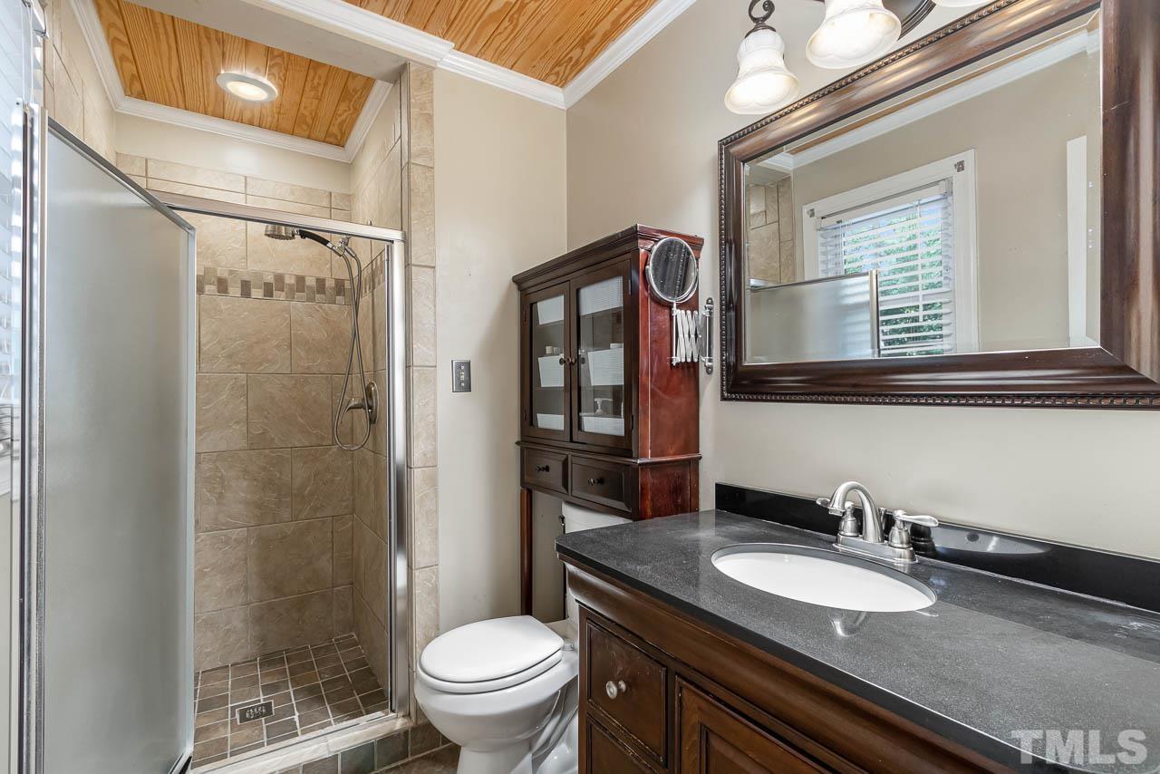 6005 Spring Valley Drive Raleigh, NC 27616 - Photo 30 of 34 a bathroom with a granite countertop sink toilet a mirror and shower
