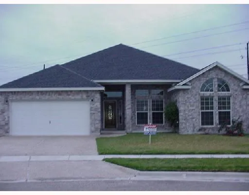 a front view of a house with a garden and plants