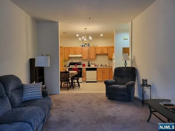 a living room with furniture and a view of kitchen