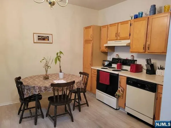 a kitchen with granite countertop a table chairs stove and cabinets