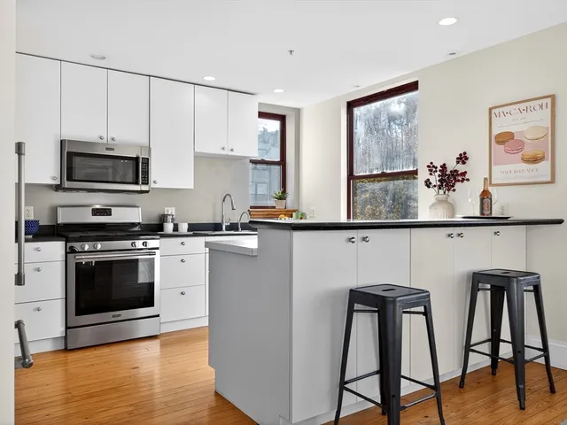a kitchen with stainless steel appliances granite countertop a stove a sink and a microwave