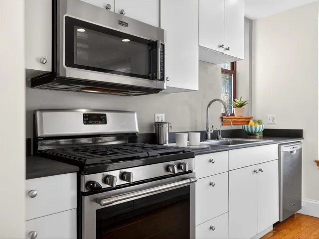 a kitchen with stainless steel appliances a stove a microwave a sink and cabinets