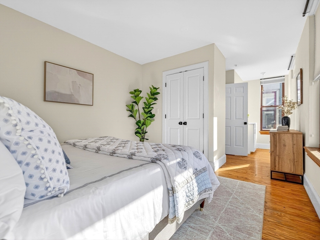 62-76 Cornwall Street, Unit 74 (E) Boston, MA 02130 - Photo 19 of 34 a bedroom with a large bed and a couch