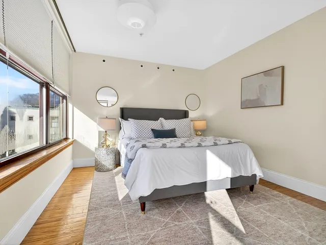 a bedroom with a bed lamp and a rug