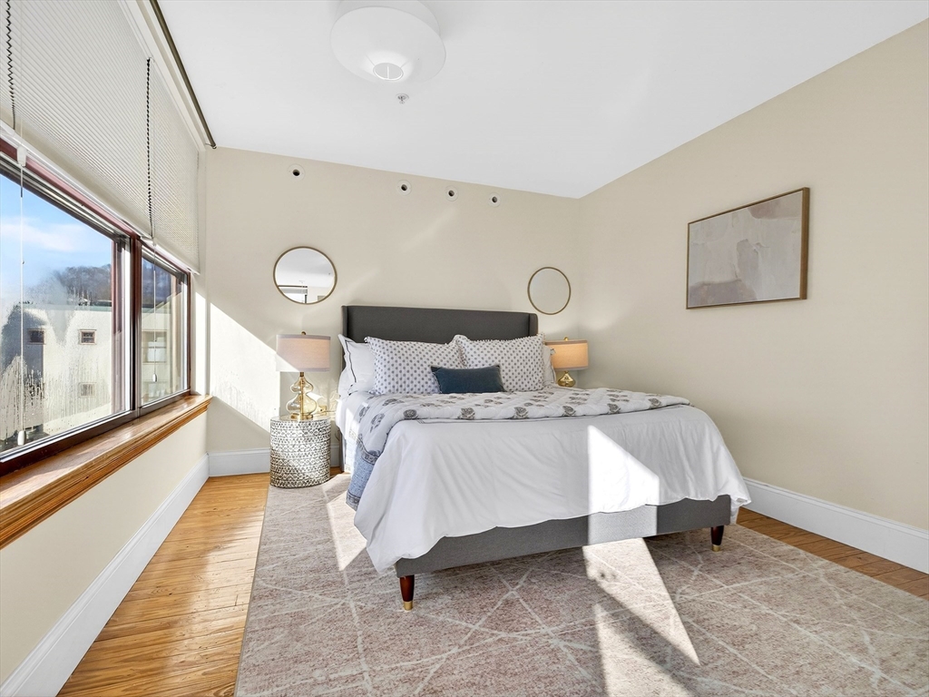 62-76 Cornwall Street, Unit 74 (E) Boston, MA 02130 - Photo 20 of 34 a bedroom with a bed lamp and a rug