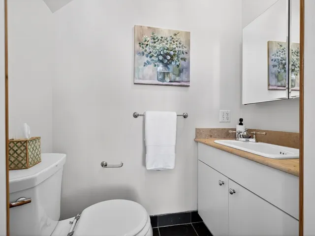 a bathroom with a granite countertop sink a toilet and a mirror
