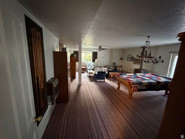 10000 North 6730th East Spring City, UT 84662 - Photo 13 of 31 Spacious lower-level room featuring patterned carpet flooring, a built-in pool cue rack, and multiple windows providing natural light