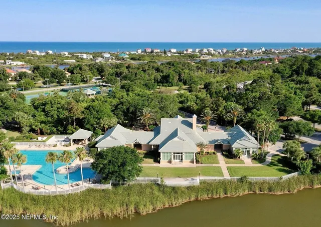 an aerial view of residential houses with outdoor space and ocean view