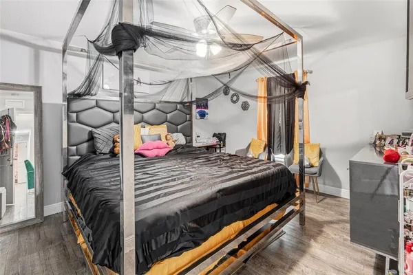 a bedroom with a bed a flat screen tv and a chandelier