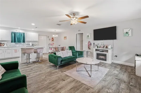 a living room with furniture a flat screen tv and kitchen view