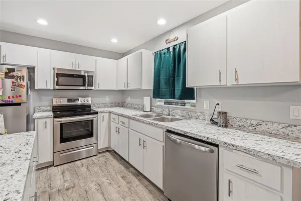 a kitchen with granite countertop a stove and a sink