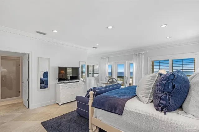 a spacious bedroom with a bed and a flat screen television