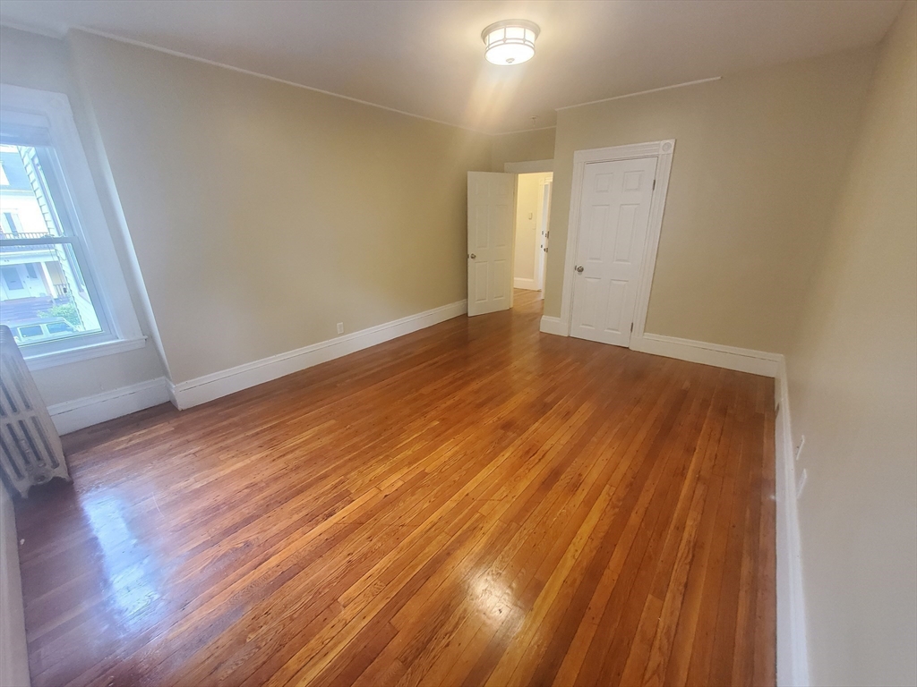 45 Intervale Street, Unit 2 Boston, MA 02121 - Photo 11 of 17 an empty room with wooden floor and windows