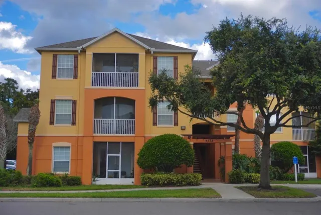 a front view of a house with a yard and trees