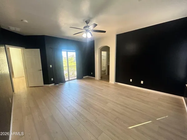 a view of an empty room with window and wooden floor