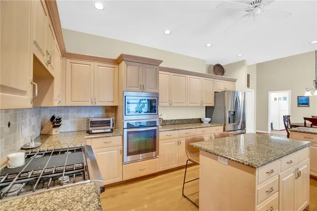 a kitchen with stainless steel appliances granite countertop a sink stove and refrigerator