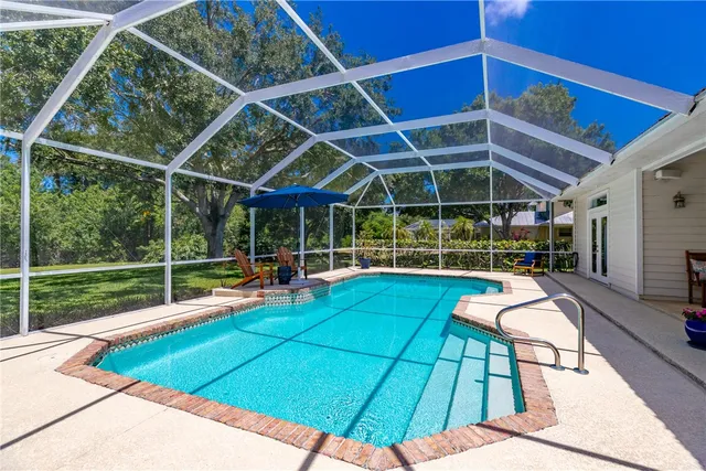 a view of a backyard with table and chairs under an umbrella