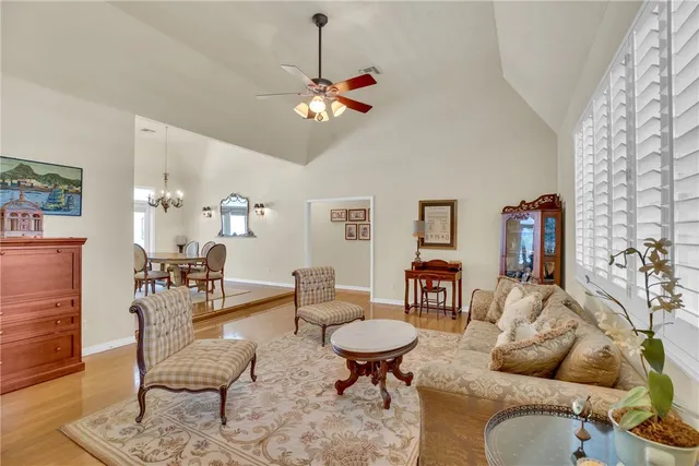 a living room with furniture a chandelier and a wooden floor
