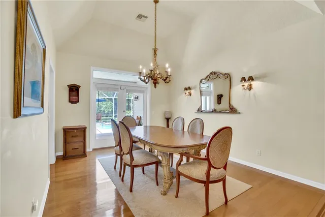 a dining room with furniture a chandelier and wooden floor