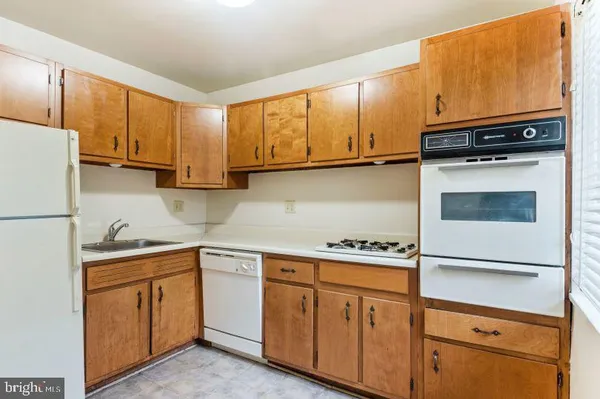 a kitchen with white cabinets and appliances